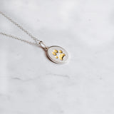 Sterling Silver oval paw print charm necklace with embedded paw filled with 24k yellow gold